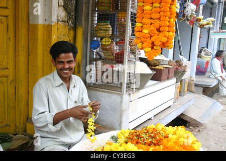 L'homme traditionnelle vente de fleurs jaune ixora à New Delhi pour le festival hindou de Durga Puja Banque D'Images