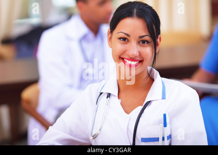 Médecin woman smiling indoors avec ses collègues travailler derrière Banque D'Images