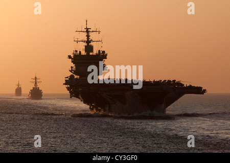 Le porte-avions USS Enterprise, missiles USS Porter et cruiser lance-missiles USS Vicksburg transit retour à leur port d'attache de Norfolk, en Virginie, au coucher du soleil le 2 octobre 2012. Banque D'Images