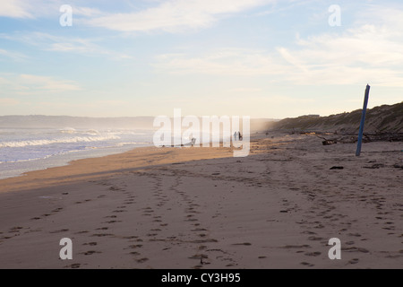 Deux personnes marchant le long d'une plage. Banque D'Images