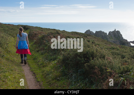 Une femme marche le long de la côte sud-ouest près du chemin Logan Rock, près de Treen à Cornwall, Royaume-Uni Banque D'Images