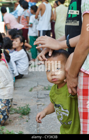 Petit garçon avec crème traditionnel Thanaka sur son visage à Rangoon, Myanmar Banque D'Images