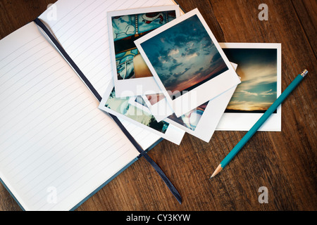 Vintage photos polaroid, un journal et un crayon. Banque D'Images