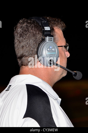 Entraîneur de football de l'école secondaire wearing headset Banque D'Images