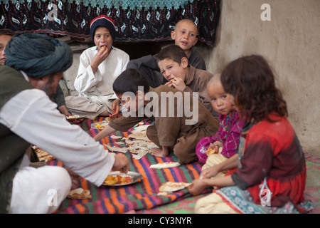 Famille afghane de déjeuner dans leur maison de terre Banque D'Images