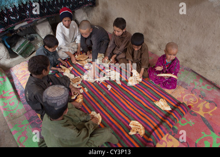 Famille afghane de déjeuner dans leur maison de terre Banque D'Images
