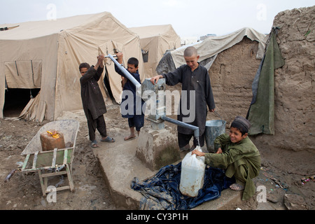 Enfant de réfugiés afghans à aller chercher de l'eau du puits Banque D'Images