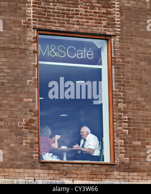 Couple moment de calme dans la fenêtre de Marks and Spencer shop cafe Worthing UK Banque D'Images