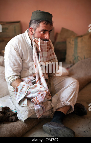 Mohammed Ayub, 43 un Waza ou cuisinier traditionnel dans la tradition du Cachemire reste entre la cuisine et le service des aliments à Wazwan fête. Banque D'Images