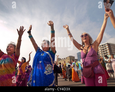 Les membres du mouvement Hare Krishna se rassemblent pour chanter et danser sur le front de mer de Brighton. Banque D'Images