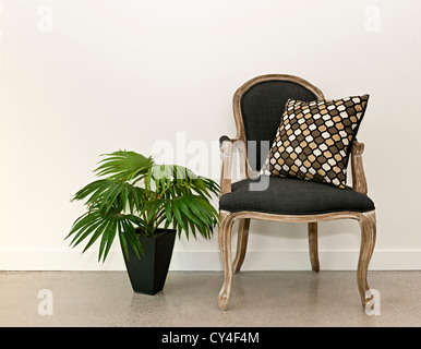 Fauteuil ancien meubles avec plante contre mur blanc, design intérieur Banque D'Images