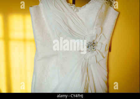 Robe de mariage se bloque sur le mur jaune en télévision Banque D'Images