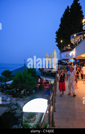 Temps de marche de nuit - les gens sur le bord de l'eau à Opatija Croatie au coucher du soleil Banque D'Images