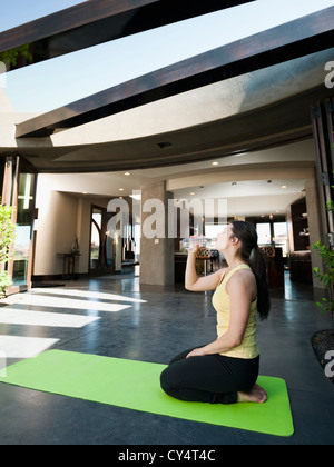 USA, Utah, Saint Georges, jeune femme séduisante en faisant une pause dans la pratique du yoga à boire de l'eau Banque D'Images