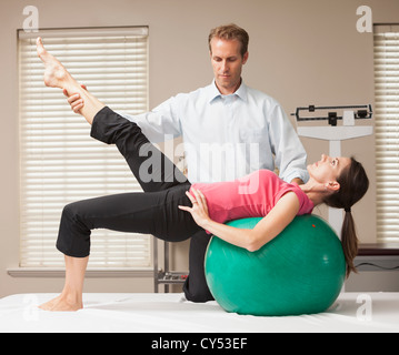 USA, Utah, Orem, young woman exercising avec l'aide d'un physiothérapeute Banque D'Images