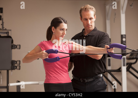 USA, Utah, Orem, young woman exercising avec l'aide d'un physiothérapeute Banque D'Images