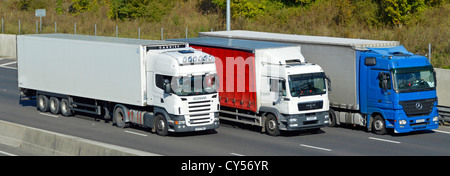 Couleurs rouge blanc et bleu sur les véhicules utilitaires de la chaîne d'approvisionnement de transport dépassant circulant le long de la route d'autoroute M25 à quatre voies Essex Angleterre Royaume-Uni Banque D'Images