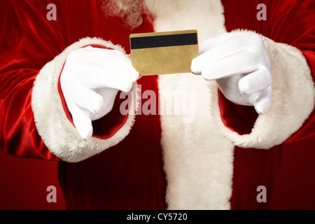 Photo de Père Noël les mains gantées holding credit card Banque D'Images