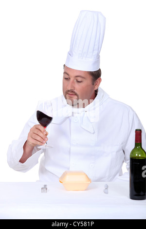 Chef avec un verre de vin rouge et fort de la malbouffe Banque D'Images