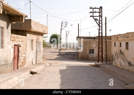 La fin d'une rue résidentielle dans la ville turque de Nusaybin, à la frontière syrienne et la ville d'al-Qamishli dans la distance. Banque D'Images