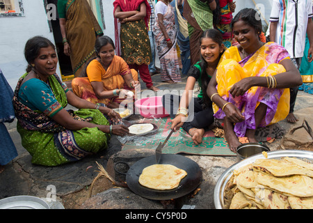 Les femmes indiennes et les filles représentant jagré doux rempli chapathi pour le Dasara festival dans un village de l'Inde rurale. L'Andhra Pradesh, Inde Banque D'Images