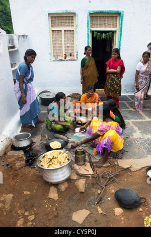 Les femmes indiennes et les filles représentant jagré doux rempli chapathi pour le Dasara festival dans un village de l'Inde rurale. L'Andhra Pradesh, Inde Banque D'Images