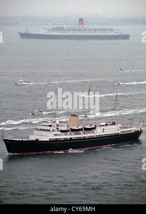 UK Angleterre SPITHEAD Yacht Royal Britannia sails passé de Cunard RMS Queen Elizabeth 2 lors de l'examen de la Gendarmerie royale dans le Solent. Banque D'Images