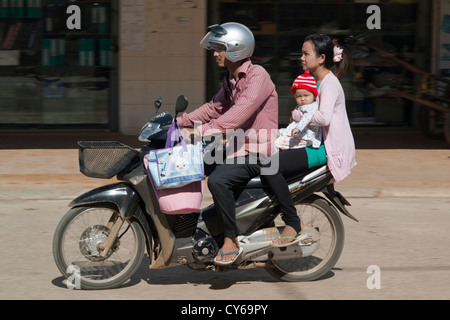 Une jeune famille passent sur leur moto dans Sisophon, Cambodge Banque D'Images