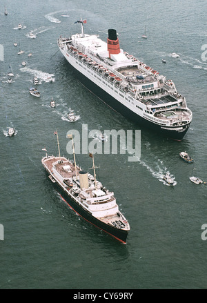 UK Angleterre SPITHEAD Yacht Royal Britannia sails passé de Cunard RMS Queen Elizabeth 2 lors de l'examen de la Gendarmerie royale dans le Solent. Banque D'Images