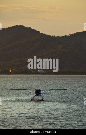 Un hydravion amarré dans le port de Cairns, Queensland, Australie au lever du soleil avec les montagnes en arrière-plan Banque D'Images