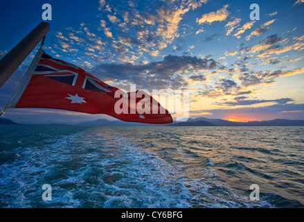 Vue sur le drapeau australien et le lever du soleil à partir de voile de quitter Cairns Harbour pour voyage plongée dans le Great Barrier Reef Marine Park Banque D'Images