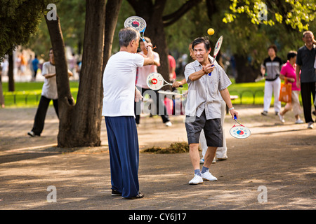 Personnes âgées Hommes chinois bailong ball play pagaie exercice tôt le matin au Temple du Ciel à Beijing au cours de l'été Parc Banque D'Images