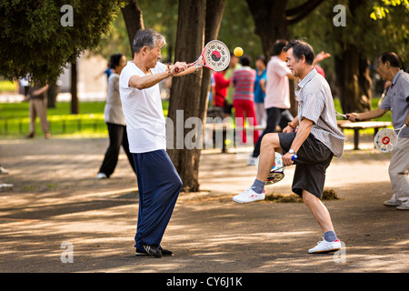 Personnes âgées Hommes chinois bailong ball play pagaie exercice tôt le matin au Temple du Ciel à Beijing au cours de l'été Parc Banque D'Images