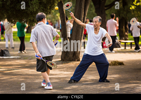 Personnes âgées Hommes chinois bailong ball play pagaie exercice tôt le matin au Temple du Ciel à Beijing au cours de l'été Parc Banque D'Images