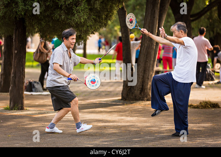 Personnes âgées Hommes chinois bailong ball play pagaie exercice tôt le matin au Temple du Ciel à Beijing au cours de l'été Parc Banque D'Images