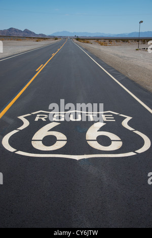 Un itinéraire Autoroute 66 shield peint sur une nouvelle route dans le désert californien Banque D'Images