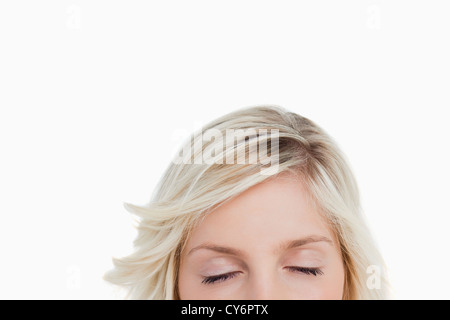 Femme fermant les yeux tout en cachant la partie inférieure de son visage Banque D'Images