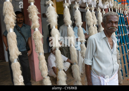 Prêtres debout devant des parasols colorés appelé Muthukuda Goureeswara aligné pour la fête du Temple, Cherai, près de Kochi (Cochin), Kerala, Inde Banque D'Images