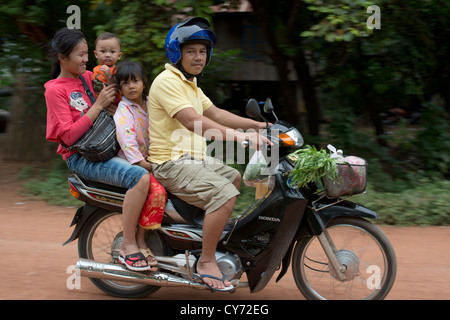 Une jeune famille passent sur leur moto dans O'Ambel village, Sisophon, Cambodge Banque D'Images