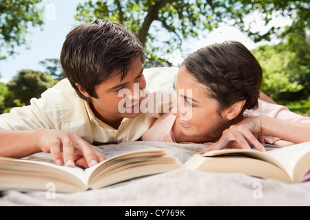 Deux amis se regarder alors que la lecture de livres sur une couverture Banque D'Images