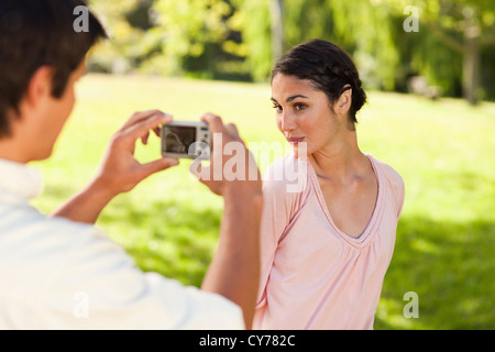 L'homme prend une photo de son ami alors qu'elle pose Banque D'Images
