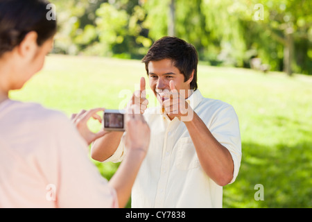 Femme prend une photo de son ami alors qu'il pose Banque D'Images