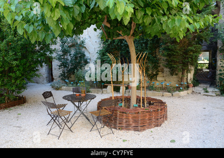 Jardin médiéval avec banc de travail en osier, fourches en bois, Table et chaises Uzès ou Uzès Gard France Banque D'Images