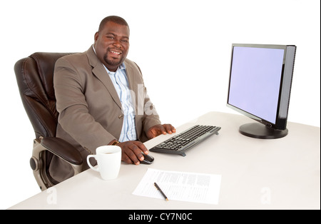 Un African American businessman est assis un son bureau tout en souriant à la caméra. Banque D'Images