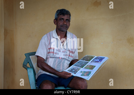 L'homme du village de Waikkal, Sri Lanka avec ses photos de la destruction du tsunami en 2004 et certains de ses proches qui ont été tués Banque D'Images