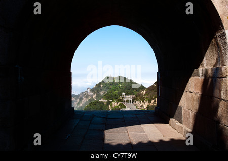 Une arche en pierre donne une vue d'un des sommet du tai shan pics dans la province de Shandong, Chine Banque D'Images