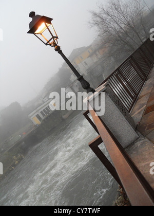 Lampadaire romantique et rivière dans un jour brumeux Banque D'Images