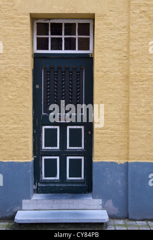 Vieille porte avant en bois bleu dans le besoin de peinture. Entrée principale est la porte d'une maison peint en jaune et bleu Banque D'Images
