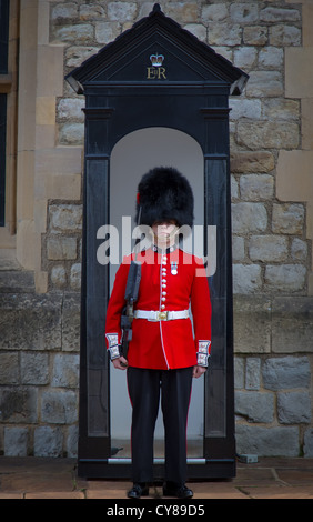 Soldat en tunique rouge et son bonnet cap à la Tour de Londres Banque D'Images