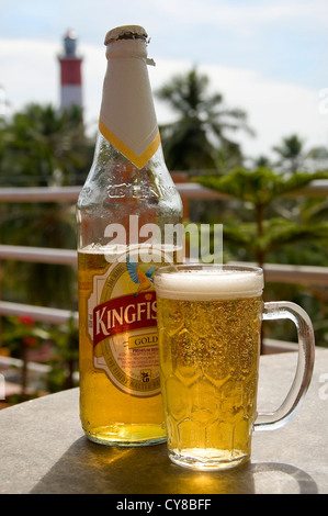 Close up vertical d'une bouteille de bière fraîche Kingfisher et un verre sur une table à Kovalam, Inde. Banque D'Images